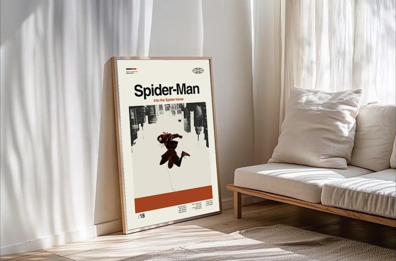 Puede incluir: Un p&oacute;ster enmarcado con el t&iacute;tulo "Spider-Man" y el subt&iacute;tulo "Into the Spider-Verse". El p&oacute;ster muestra un paisaje urbano y una figura de Spider-Man sobre un fondo beige. El marco es de madera clara. El p&oacute;ster est&aacute; apoyado contra una pared.
