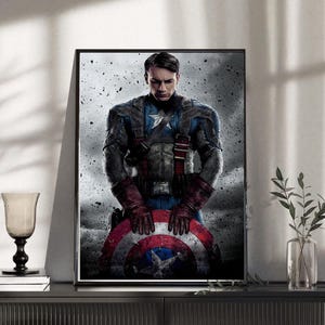 May include: Framed print featuring Captain America, holding his shield. The artwork depicts the superhero in his iconic costume, with a star on his chest and a red, white, and blue shield. The image has a gritty, textured background.