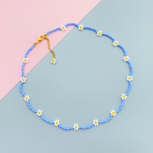Collar de cuentas con pequeñas flores de margaritas azules y blancas