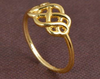 May include: A gold-coloured ring with a Celtic knot design.
