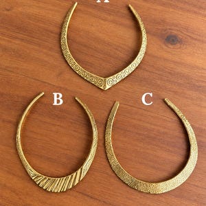 May include: Three gold-toned metal collar necklaces labeled A, B, and C. Necklace A has a V-shape with spiral patterns. Necklace B is rounded with diagonal ribbed textures. Necklace C is rounded with a fine, dense, textured surface pattern.