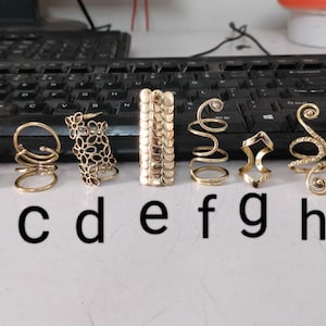 以下が含まれることがあります： aからjまでラベル付けされた、さまざまなスタイルの10個の金色のヘアリング