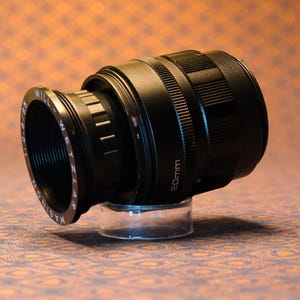 Puede incluir: Una taza de cer&aacute;mica blanca con un asa negra y el texto "But First, Coffee" en negro y negrita. La taza est&aacute; sobre una superficie blanca. La taza mide aproximadamente 10 cm de alto.