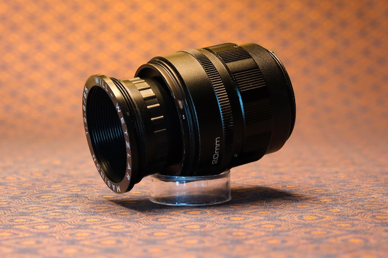 Puede incluir: Una taza de cer&aacute;mica blanca con un asa negra y el texto "But First, Coffee" en negro y negrita. La taza est&aacute; sobre una superficie blanca. La taza mide aproximadamente 10 cm de alto.