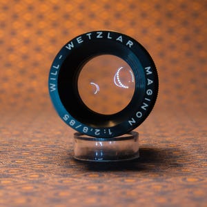 Puede incluir: Una taza de cer&aacute;mica blanca con un asa negra y el texto "But First, Coffee" en un estilo manuscrito. La taza est&aacute; sobre una superficie blanca. La taza mide 10 cm de alto.