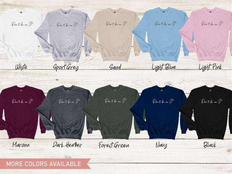 Puede incluir: Una colecci&oacute;n de diez sudaderas con cuello redondo en varios colores, incluyendo blanco, gris deportivo, arena, azul claro, rosa claro, granate, gris oscuro, verde bosque, azul marino y negro. Cada sudadera tiene el texto "Don't be an o" en blanco.