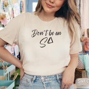 T-shirt featuring text Don't be an S Delta in a paintbrush font. Playful reminder for Registered Behavior Technicians (RBTs) and Applied Behavior Analysis (ABA) therapists.