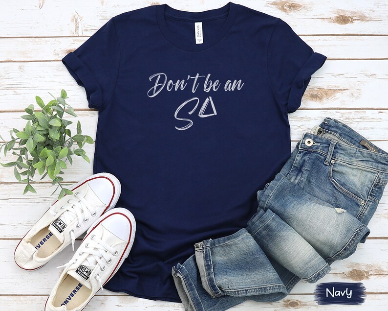 T-shirt featuring text Don't be an S Delta in a paintbrush font. Playful reminder for Registered Behavior Technicians (RBTs) and Applied Behavior Analysis (ABA) therapists.