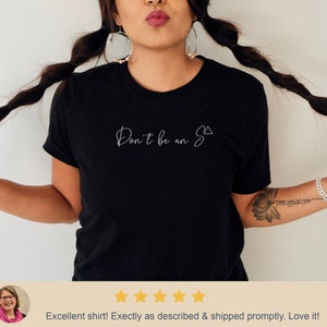 May include: Black t-shirt with white text that reads "Don't be an S" with a triangle symbol.