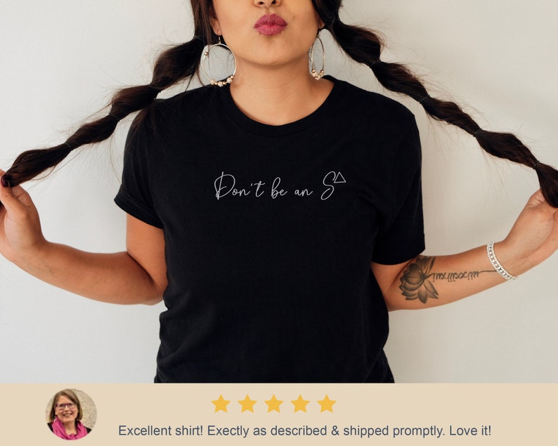 May include: Black t-shirt with white text that reads "Don't be an S" with a triangle symbol.