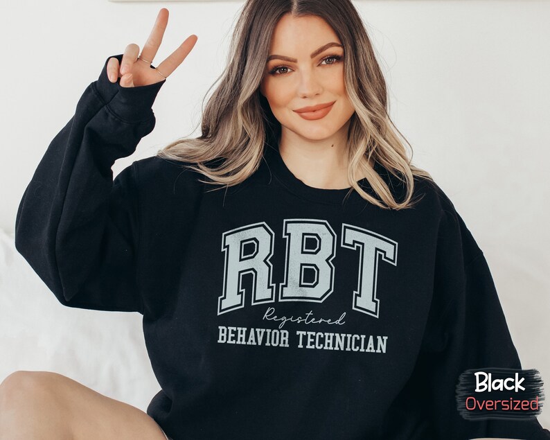 May include: Black oversized sweatshirt with the text "RBT Registered Behavior Technician" in white lettering.