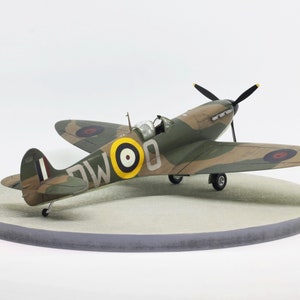 Built Spitfire Mk.II 1/48 model aircraft on a round wooden base plate with concrete pattern
