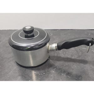 Puede incluir: Una pequeña cacerola plateada con tapa y asa negras. La tapa tiene un anillo blanco y un pomo negro. El asa es negra y curvada. La cacerola está diseñada para cocinar.