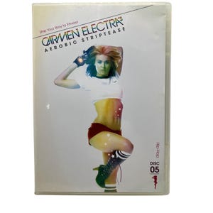 May include: A DVD case featuring Carmen Electra's Aerobic Striptease. The cover shows Electra in a white top, red shorts, and black and white striped socks. The text reads "Strip Your Way to Fitness!" and "Hip-Hop Disc 05".