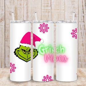 May include: Three white stainless steel tumblers with a Grinch design. The tumblers have a green Grinch face with a pink Santa hat, pink snowflakes, and the text "Grinch Vibes" in green and pink neon letters.