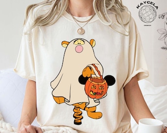 Op de afbeelding: Crèmekleurig T-shirt met een Halloween-thema. Het ontwerp toont een cartoon tijger karakter verkleed als een spook, met een pompoenvormige snoepemmer. Het woord "NATURAL" is gedrukt op een cirkelvormig label.