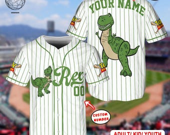 May include: White baseball jersey with green pinstripes, featuring a cartoon dinosaur graphic. The jersey has "Rex" and "00" on the front, and "YOUR NAME" on the back. Includes "CUSTOM NAME" and "CUSTOM NUMBER" options. The text "ADULT/ KID/ YOUTH BASEBALL JERSRY" is also visible.