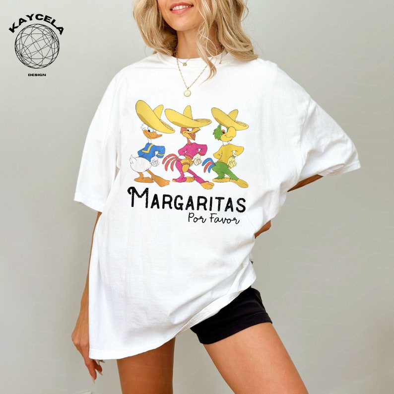 May include: White t-shirt with a graphic of three cartoon characters wearing sombreros and the text "Margaritas Por Favor".