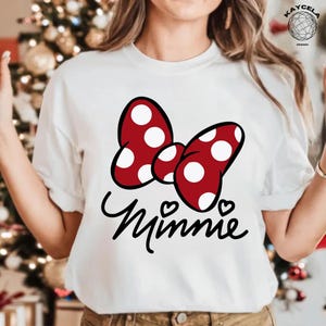 May include: White t-shirt with a red bow with white polka dots and the word "Minnie" in black script.
