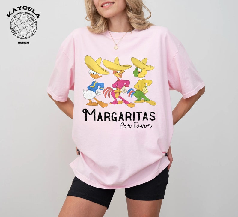 May include: Pink t-shirt with a graphic of three cartoon characters wearing sombreros and the text "Margaritas Por Favor".