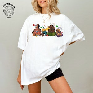 K&ouml;nnte beinhalten: Wei&szlig;es T-Shirt mit einer bunten Grafik von Figuren aus dem Film Vaiana, die "Mama" buchstabieren.