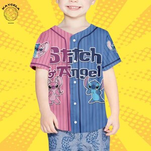 May include: A short-sleeved baseball jersey with a split design in pink and blue vertical stripes. The jersey features the text "Stitch & Angel" and cartoon character graphics. The button-down jersey is worn by a child.