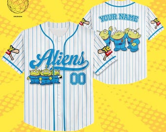 May include: White baseball jersey with blue pinstripes, featuring the word "Aliens" in blue script and the number "00". The jersey has cartoon alien graphics and the text "YOUR NAME" on the back. The sleeves have a "Toy Story" logo.