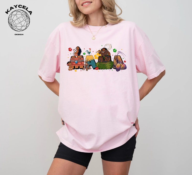 K&ouml;nnte beinhalten: Ein pinkfarbenes T-Shirt mit einer bunten Grafik von Figuren aus dem Film Vaiana. Die Grafik enth&auml;lt die Figuren Maui, Vaiana, Pua und Hei Hei. Die Grafik ist so angeordnet, dass sie das Wort "Vaiana" buchstabiert.