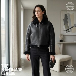 Puede incluir: Una taza de cerámica blanca con asa negra y el texto "But First, Coffee" en negrita negra. La taza se encuentra sobre un fondo borroso, sugiriendo un ambiente acogedor.