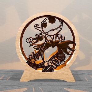 May include: A wooden, circular light fixture featuring a laser-cut design of Jack Skellington from The Nightmare Before Christmas. The light has a warm glow and sits on a wooden stand. The design is brown and the background is a soft white.