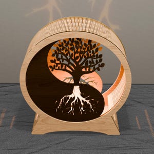May include: A wooden decorative piece featuring a tree design within a Yin and Yang symbol. The tree has detailed leaves and roots, with a light-colored wood frame and a patterned top. The design is illuminated with warm orange light.