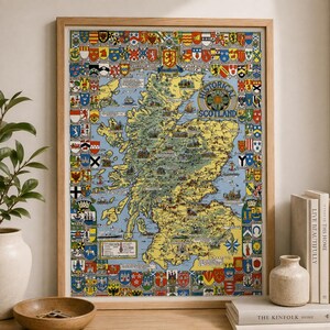 May include: A framed historical map of Scotland featuring a yellow landmass on a light blue background, surrounded by a decorative border of colourful heraldic shields and crests. The map includes the text Historical Map of Scotland.