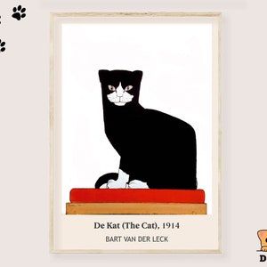 May include: A framed art print featuring a black and white cat sitting on a red cushion atop a wooden base. The text reads De Kat (The Cat), 1914 and BART VAN DER LECK. Five black paw prints are positioned in the upper left corner of the image.
