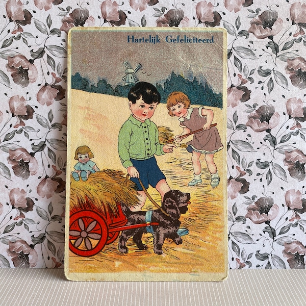 vintage, carte postale hollandaise, fille et avec un chien avec une poupée sur une calèche. foin, moulin à vent, joyeux anniversaire