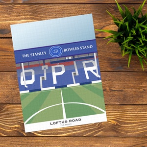 Könnte beinhalten: Eine blaue und weiße Illustration des Loftus Road, der Heimat des Queens Park Rangers Football Club. Die Illustration zeigt die Tribünen des Stadions, den Rasen und das Wappen der Mannschaft. Der Text "The Hoops" ist ebenfalls enthalten.