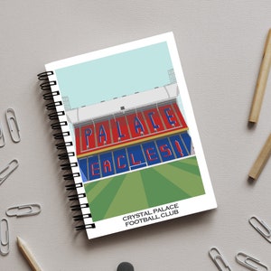 May include: A spiral bound notebook featuring a colourful illustration of a stadium with the words "Palace" and "Eagles" on the front. The text "Crystal Palace Football Club" is printed below the illustration.
