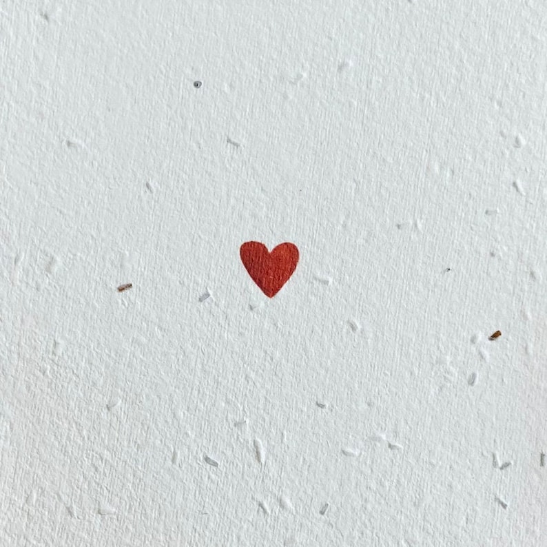 K&ouml;nnte beinhalten: Ein einzelnes rotes Herz auf wei&szlig;em Hintergrund mit gesprenkelter Textur.