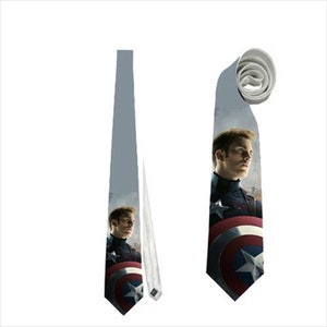 May include: A gray necktie featuring a portrait of a man in a navy blue uniform with a red, white, and blue shield. The tie is displayed flat and rolled, showcasing the design and fabric.