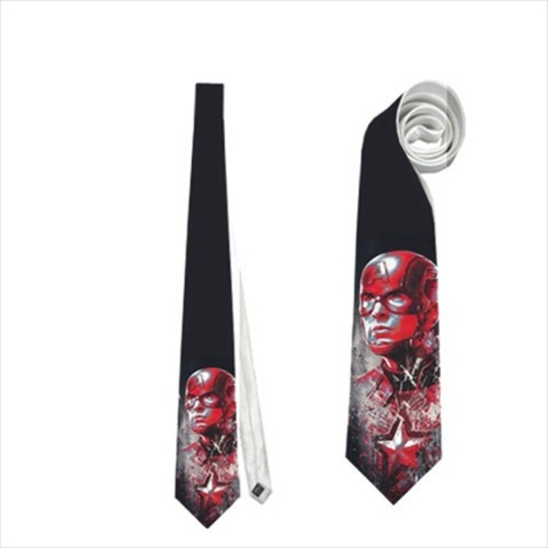 May include: Black necktie featuring a Captain America graphic. The tie displays a red and white illustration of Captain America's face and a star emblem. The tie is shown both flat and rolled up.