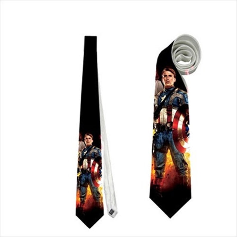 May include: A black necktie featuring a Captain America design. The tie displays a full-body image of Captain America with his shield against a fiery background. The tie is shown both flat and rolled.