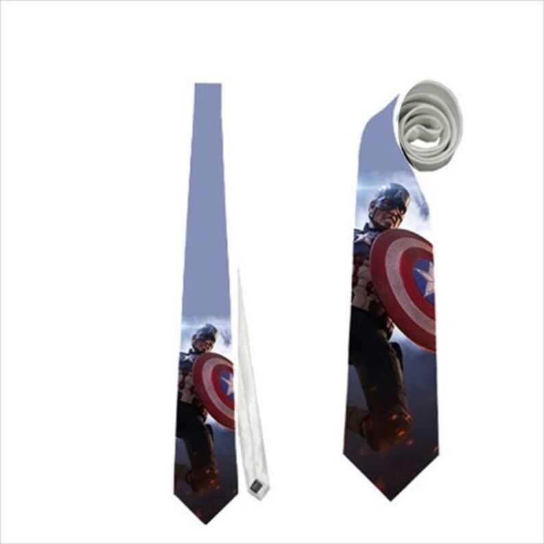 May include: A light blue tie featuring Captain America holding his shield. The tie has a repeating image of the superhero and his shield. The tie is made of a smooth material and is suitable for formal or casual wear.