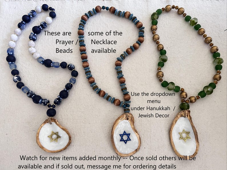 May include: Three beaded necklaces with oyster shell pendants. The necklaces feature blue, brown, and green beads. Each pendant has a Star of David design. Text on the image says "Prayer Beads" and "Necklace available."