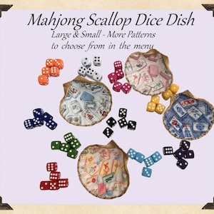 May include: A collection of scallop-shaped dice dishes with various patterns, accompanied by sets of colorful dice. The dishes feature unique fabric designs, and the dice are in shades of orange, white, pink, black, green, red, blue, yellow, and purple. Text on the image reads "Mahjong Scallop Dice Dish".