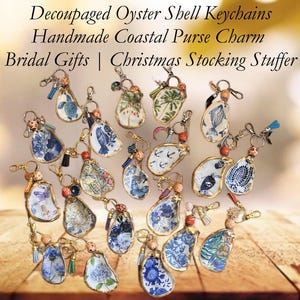 May include: A collection of decoupage oyster shell keychains and purse charms. The shells feature various designs, including floral patterns, nautical themes, and butterflies, with gold-colored edges. The text in the image reads: "Decoupaged Oyster Shell Keychains, Handmade Coastal Purse Charm, Bridal Gifts | Christmas Stocking Stuffer."
