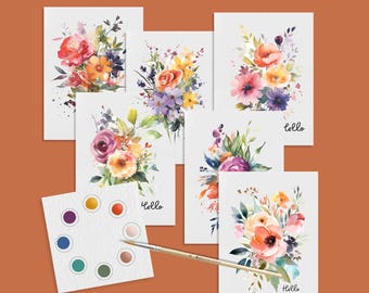 May include: Watercolor floral art prints featuring bouquets of roses, peonies, and other flowers in shades of pink, orange, yellow, and purple. Includes a palette of colors and a paintbrush. The word "Hello" is written on some of the cards.