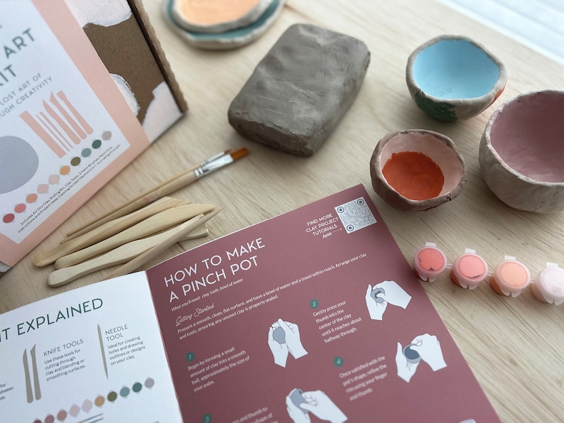 May include: A craft kit for making pinch pots with clay, tools, paint, and instructions. The kit includes a block of clay, wooden tools, small paint pots, and a booklet with instructions on how to make a pinch pot.