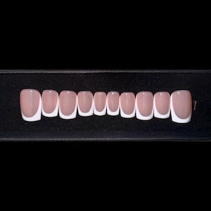 May include: Ten pink and white false nails with a French manicure design.
