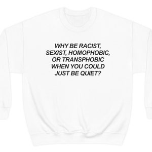 Puede incluir: Sudadera blanca con el texto negro: "WHY BE RACIST, SEXIST, HOMOPHOBIC, OR TRANSPHOBIC WHEN YOU COULD JUST BE QUIET?" La prenda tiene cuello redondo y mangas largas.