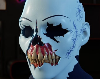 May include: A white, cracked, and broken mask with a skull design. The mask has a red mouth with teeth and black eyes. The mask is on a black and silver stand.