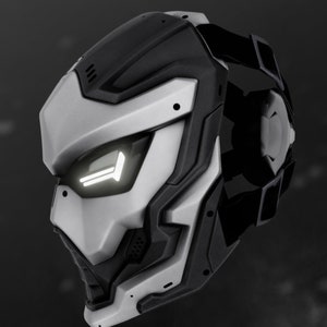 May include: A futuristic-looking silver and black helmet with a white light on the front. The helmet has a strap on the back and a textured design.